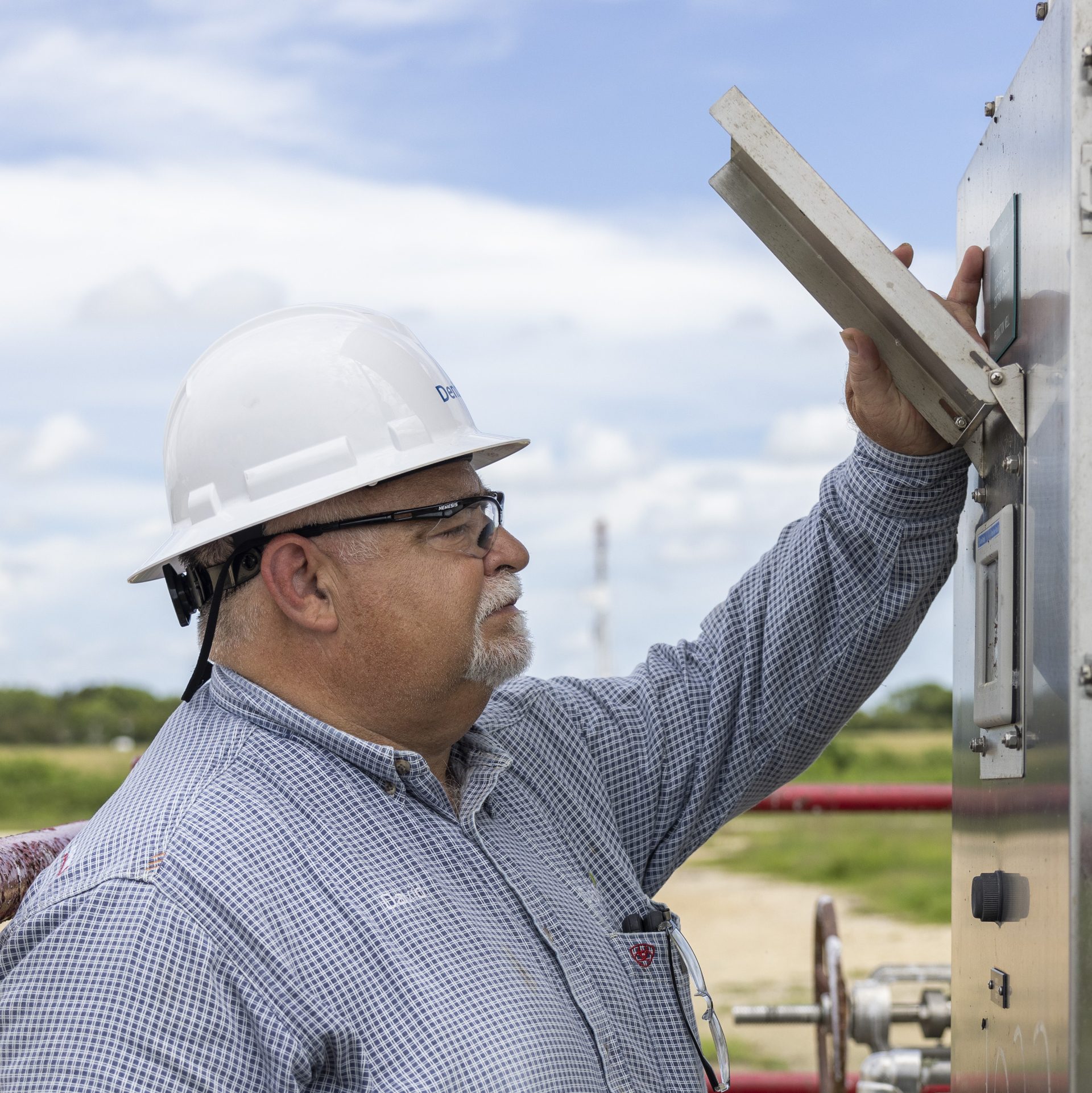 A Denbury employee checking equipment.