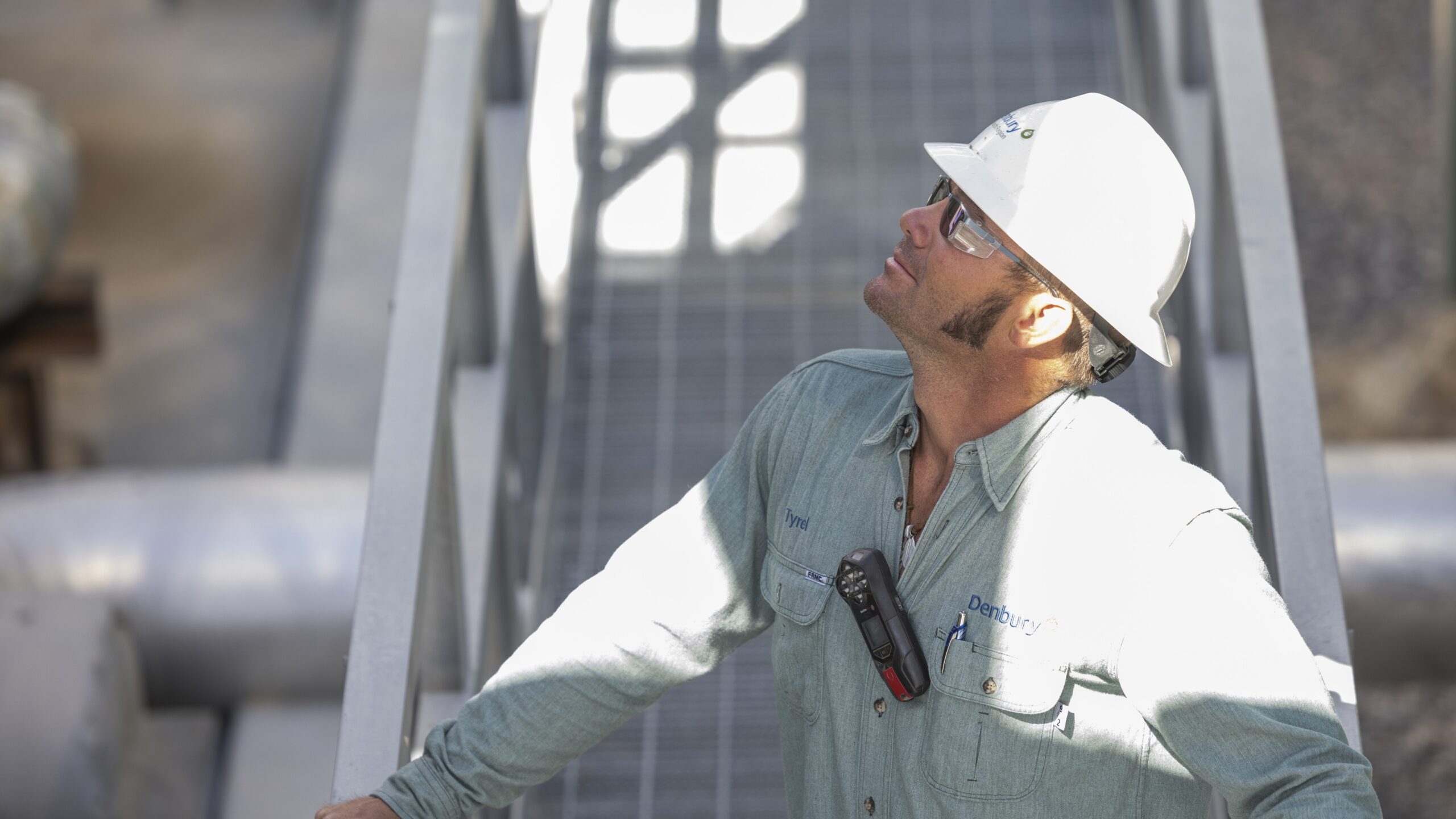 A man looking upward at one of Denbury's operation sites.